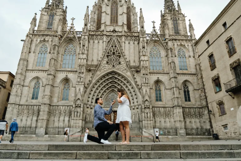 Wide shot of a surprise proposal on the grand stone steps of the Barcelona Cathedral early morning