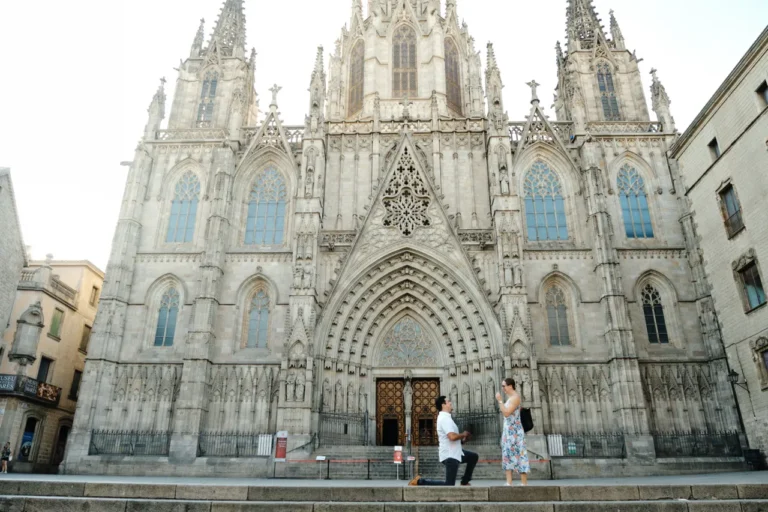 Wide shot of a surprise proposal on the grand stone steps of the Barcelona Cathedral.