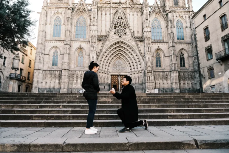 Marriage proposal on one knee in the historic Plaça de la Seu in front of the Gothic Cathedral.