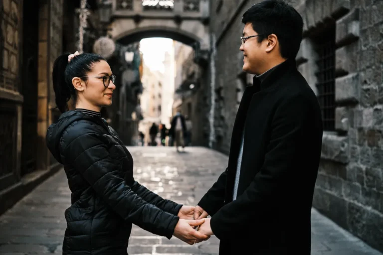 Candid engagement moment captured with warm sunlight in a historic Barcelona alleyway.