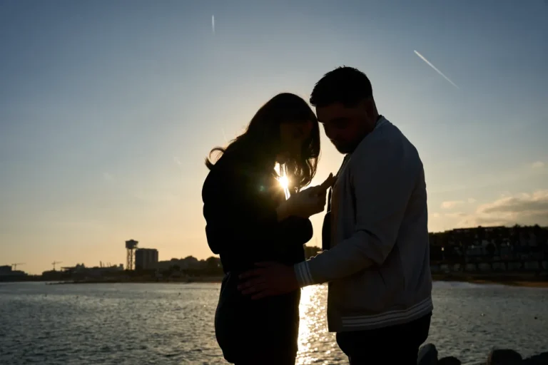 Couple proposing on the sand with the W Hotel and Mediterranean coastline behind.