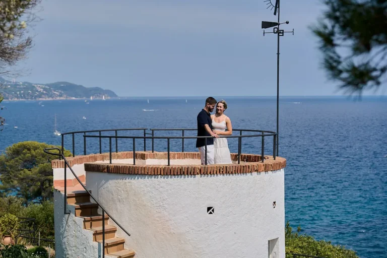 Wide shot of a couple celebrating their engagement at the Blanes botanical cliffs.
