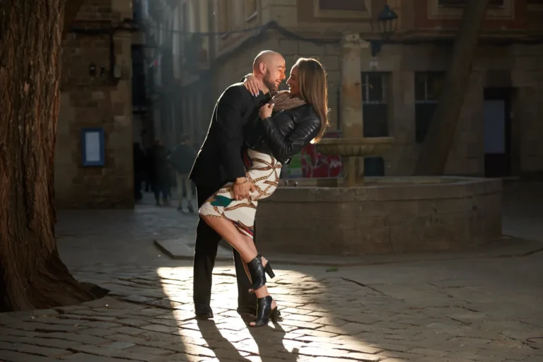 Cinematic silhouette of a couple kissing in a historic sun-lit square of the Gothic District.