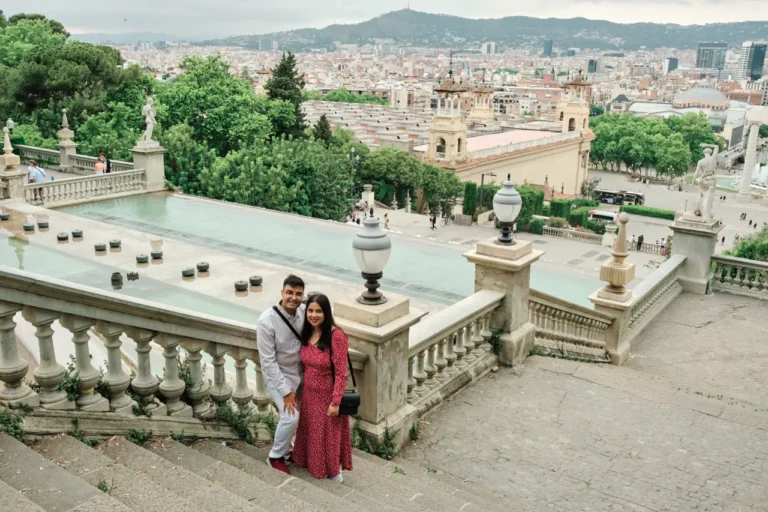 Newly engaged couple embracing at the Montjuïc overlook during the golden hour.