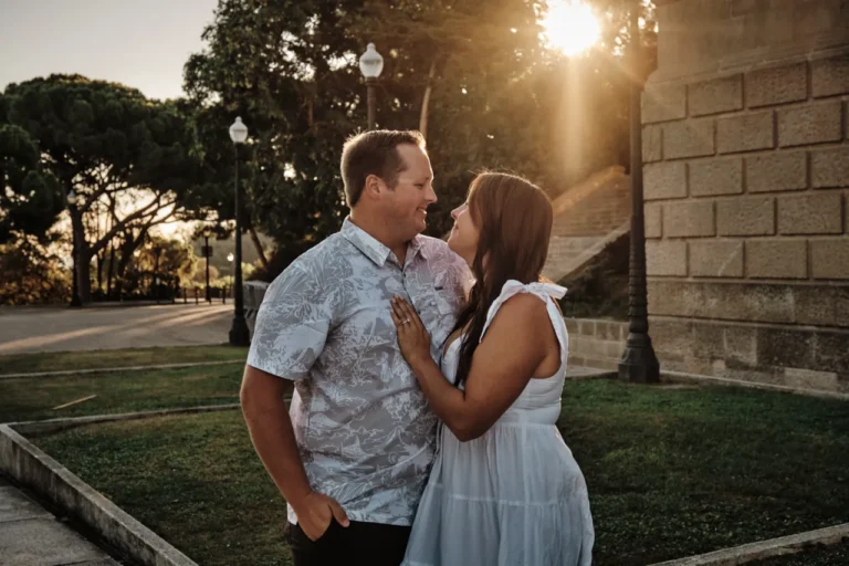 Couple sharing a romantic hug at sunset on the grand steps of the MNAC museum.