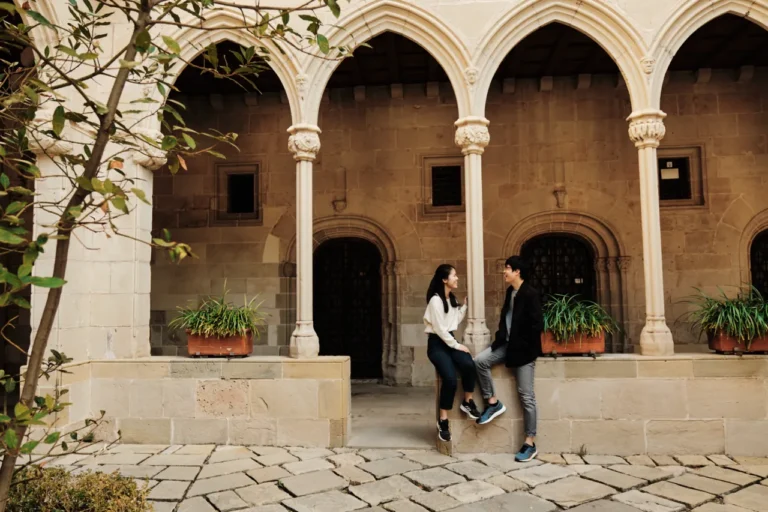 Romantic couple portrait under the arched stone corridors of the Montserrat Monastery.
