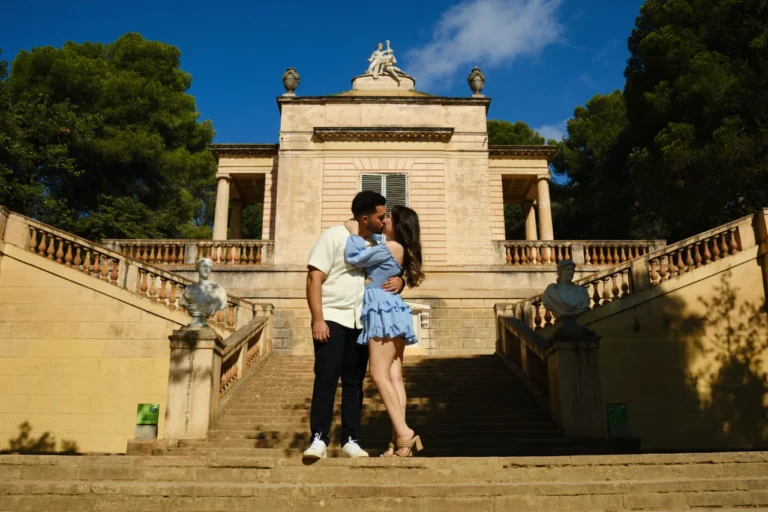 Romantic embrace on the grand stone staircase of the Horta Labyrinth neoclassical pavilion.