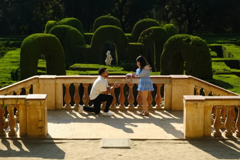 Man proposing on a neoclassical stone balcony overlooking the Horta Labyrinth maze.