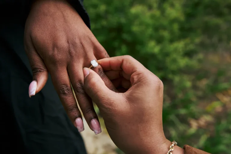 Artistic close-up of a diamond ring on a woman's hand during a proposal in a Barcelona park.