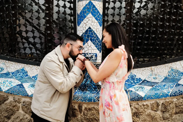 Intimate engagement kiss with the iconic Gaudí architecture in the background.
