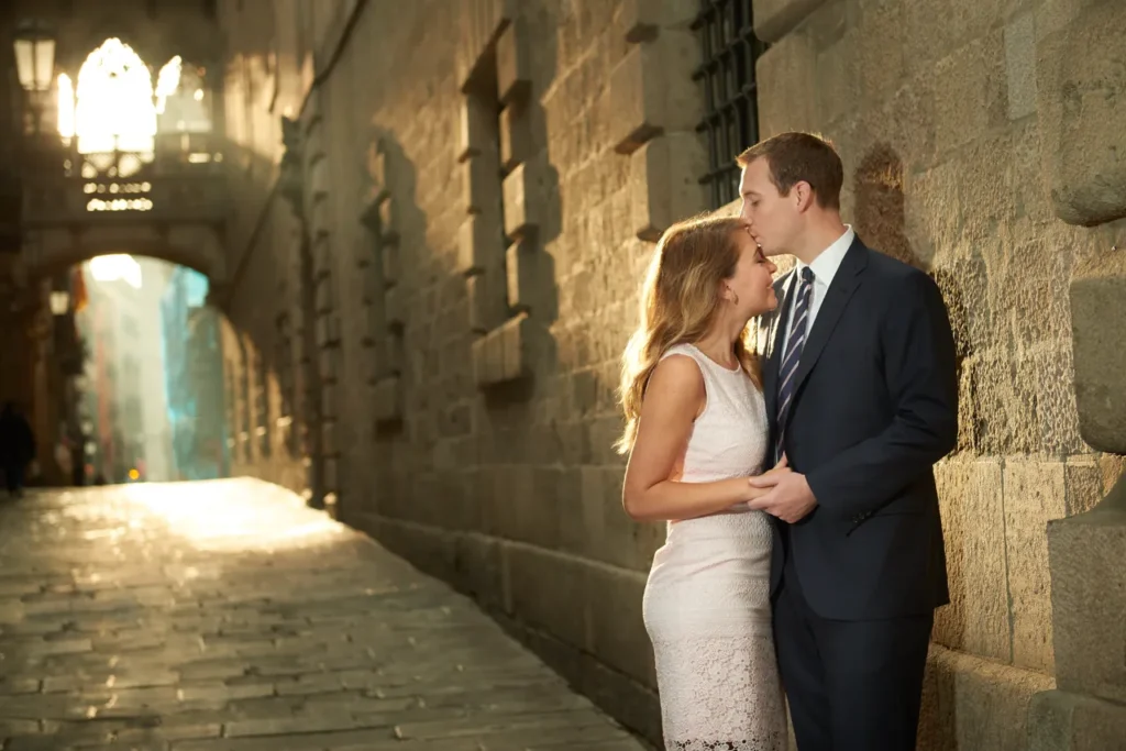 Romantic couple walking hand-in-hand through a medieval stone alley in El Born.
