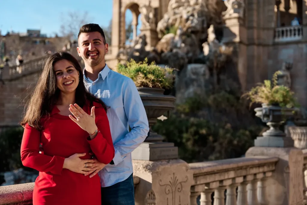 Close-up portrait of an engaged couple smiling at the Ciutadella Park gardens.