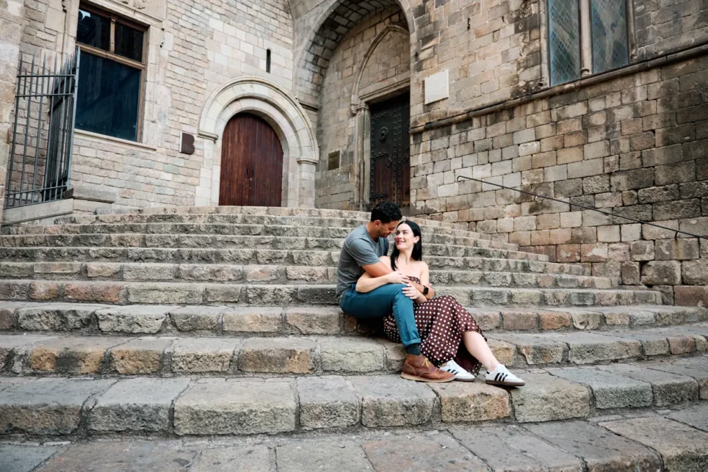 Engagement session with a couple sitting on the historic stone steps of Barcelona's old town.
