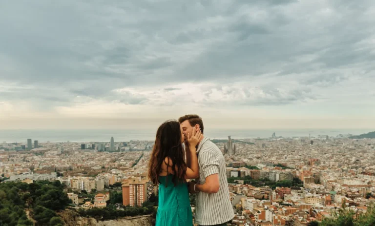 Candid moment of a couple embracing overlooking the Barcelona skyline.