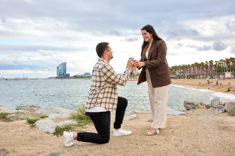 Engagement proposal on the rocks by the sea with the W Hotel Barcelona background.