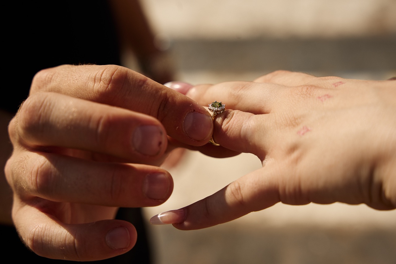 Man proposing marriage, placing engagement ring on woman’s finger barcelona photographer
