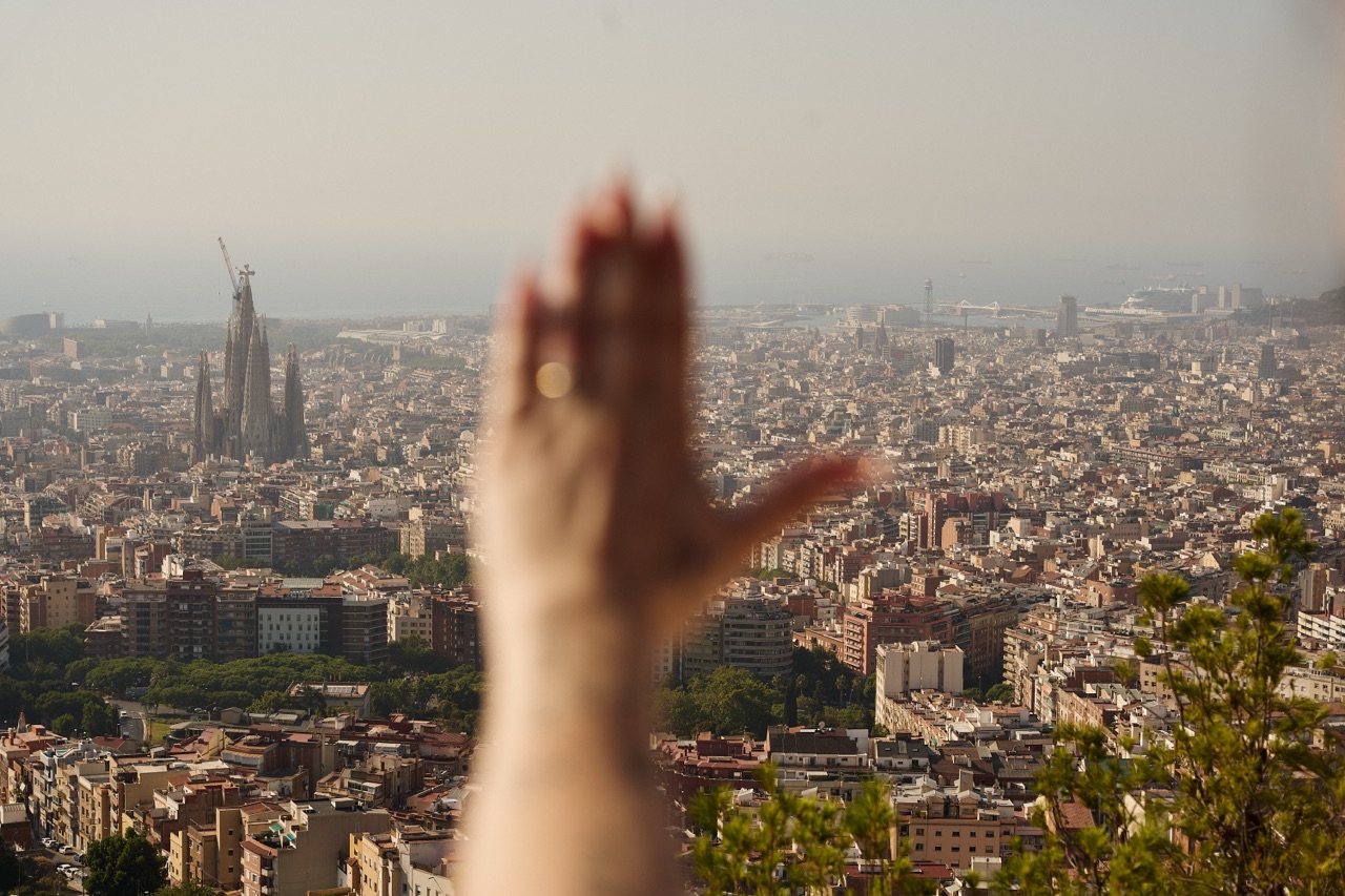 Woman’s hand showing engagement ring against barcelona city view barcelona photographer