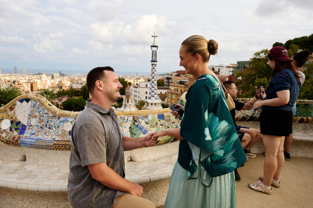 Surprise proposal at Park Güell photographed among other visitors on the terrace